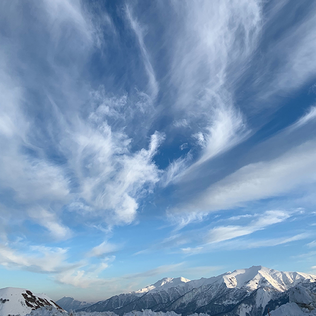 cloudy skies above high mountains with snow