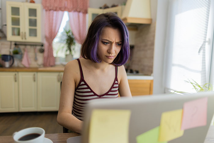 woman with pink hair on laptop